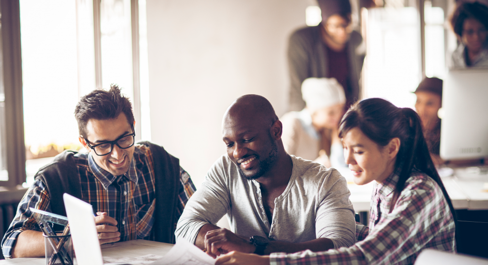 image of 3 people happily working together at a desk