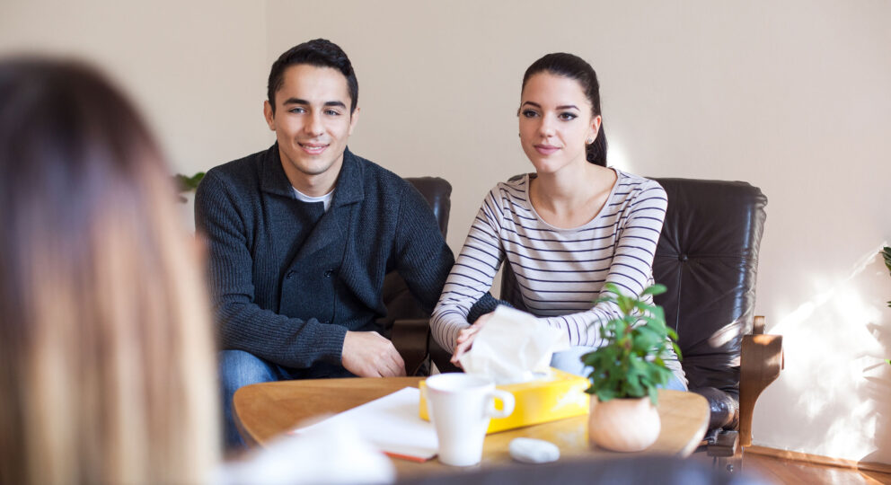 Stop the stigma around couples therapy. Image of couple talking with therapist.