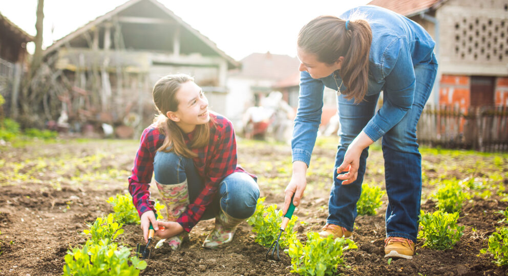 Mother with teen child gardening together