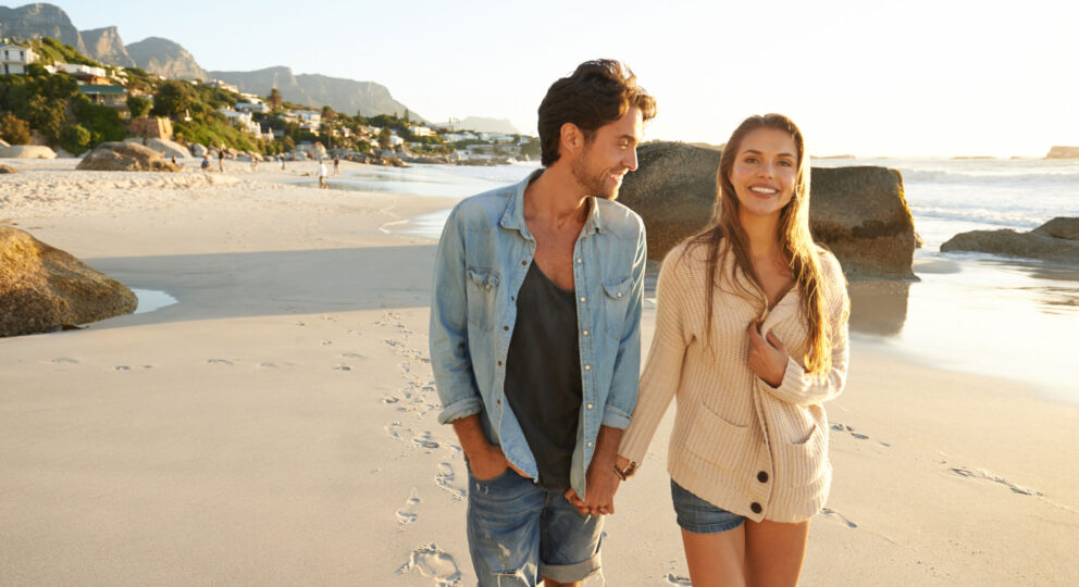 Understanding must precede advice. Image of couple walking on the beach and talking happily.