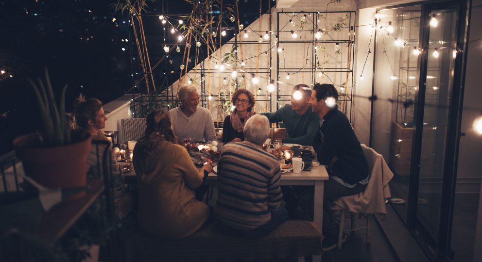 Photo of a family around the dinner table for Passover, shown laughing and enjoying each other's company.