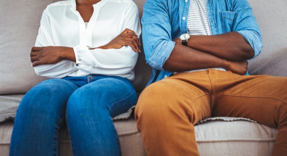 Black couple sitting with arms crossed