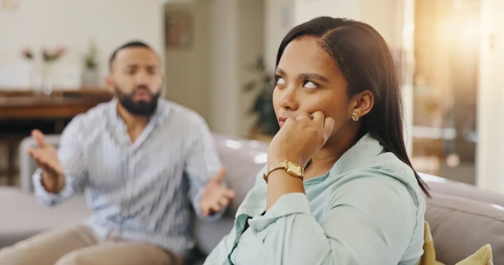 Couple arguing with one partner rolling eyes- a sign of contempt according to Dr. John Gottman.