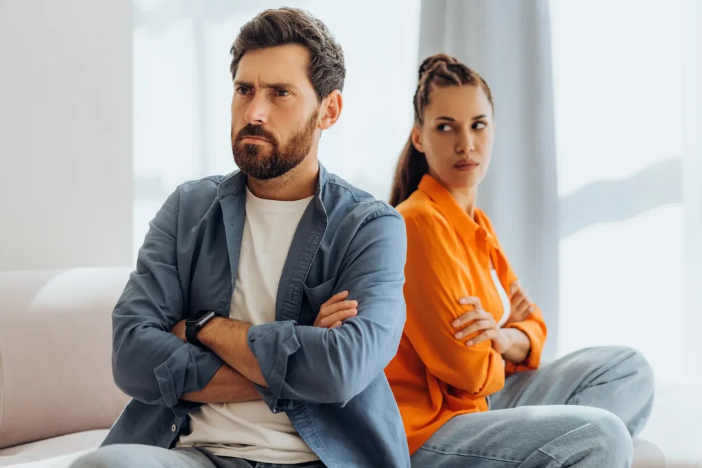 Couple arguing where one partner has arms crossed which Dr. John Gottman calls stonewalling.