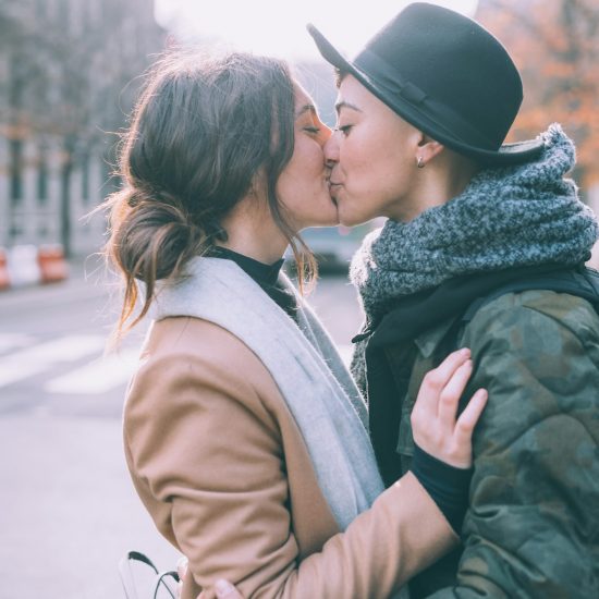 two women lesbian couple outdoors kissing